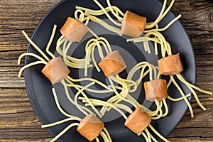spaghetti with sausages in the form of spiders. Happy kid food for Halloween party. Top view