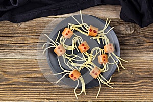 spaghetti with sausages in the form of spiders. Happy kid food for Halloween party. Top view with copyspace