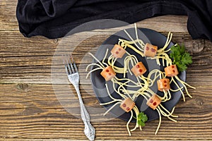 spaghetti with sausages in the form of spiders. Happy kid food for Halloween party. Top view with copyspace