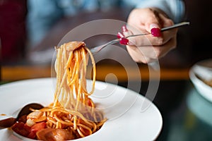 Spaghetti and sausages with sauce.