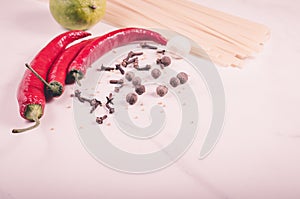 Spaghetti and seasonings for preparation/spaghetti and seasonings for preparation on a white marble background. Copy space