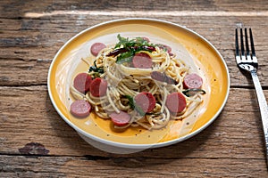 Spaghetti spicy with sausage in yellow dish