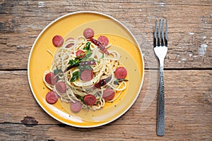 Spaghetti spicy with sausage in yellow dish