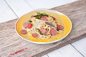 Spaghetti spicy with sausage in yellow dish