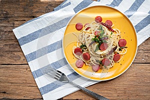 Spaghetti spicy with sausage in yellow dish