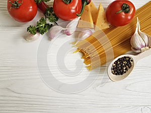 Spaghetti, tomato, garlic, pepper, butter, healthy dinner cheese on a wooden background