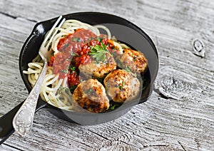 Spaghetti with tomato sauce and chicken meatballs in a pan