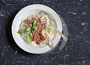 Spaghetti with vegetarian lentil bolognese on a dark background. photo