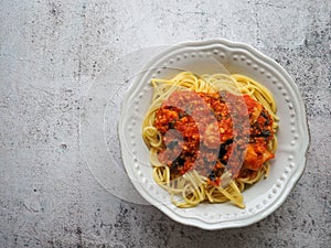 Spaghetti with vegetarian soy bolognese on white rustic background with copy space