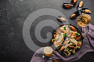 Spaghetti vongole, Italian seafood pasta with clams and mussels, in plate with herbs on rustic stone background. Traditional