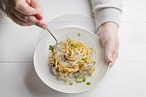 spaghetti on white plate with green onion
