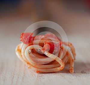 Spaghetti wound on a fork with tomatoes and basil.