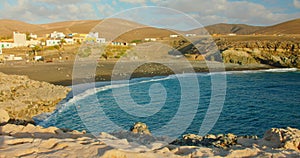 Spain, Canary Islands, Fuerteventura, sandy volcanic beach in little town Ajuy. Blue ocean waves crash on black seashore