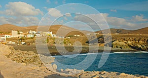 Spain, Canary Islands, Fuerteventura, sandy volcanic beach in little town Ajuy. Playa de Ajuy. Cityscape with resort