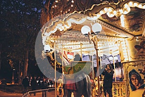 SPAIN - DECEMBER 12: Woman takes picture of her childing riding a carrousel on the street, DECEMBER 12, 2017 in Madrid, Spain