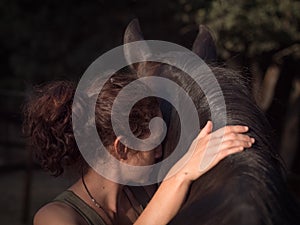 Spain, Horizontal backview of female forming bond with andalusian mare.