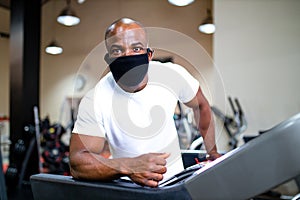 Spain man in white cotton t-thirt wearing mask while working out in gym