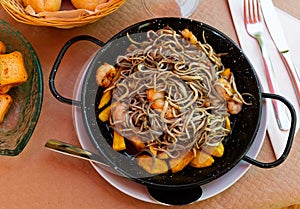 Spainsh dish seafood fried baby eels and prawns with potatoes