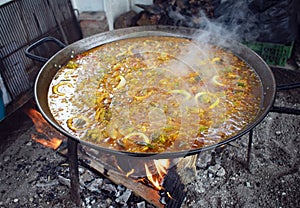 On Spainâ€™s Costa del Sol. A sizzling dish of Paella, being cooked at an open air sea-side restaurant.