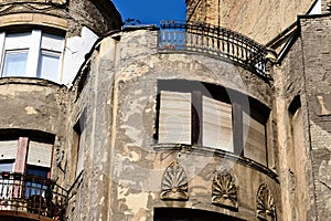 spalling decorative stucco finish on old stucco finished residential building elevation in Budapest