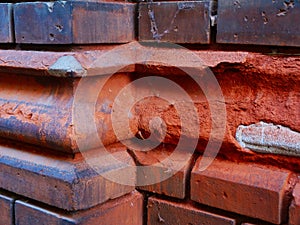 Spalling, deteriorating old exterior red brick facade detail