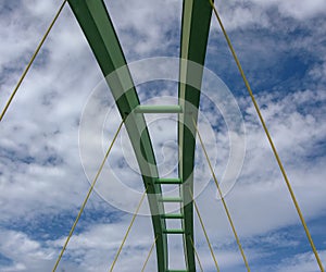 Span of an arched bridge against a blue sky with clouds