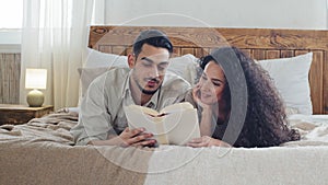 Spaniard married couple bearded husband and curly wife boyfriend and girlfriend hispanic man and woman lie on bed at