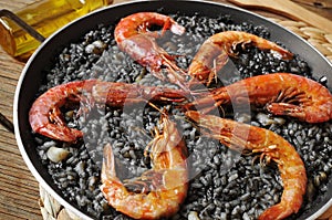 spanish arroz negro, a typical rice casserole made with squid in photo