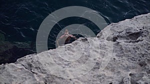 Spanish boy with a ponytail staying afloat in the water at sea