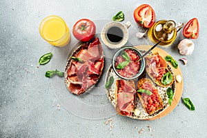 Spanish breakfast. Jamon Iberico ham and tomate bread with coffee and juice on a light background. Long banner format photo