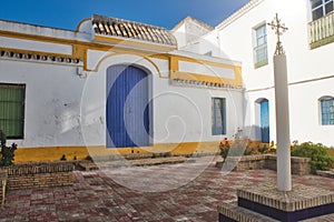 Spanish brightly colored courtyard in the sun with an ornate cross on a column photo