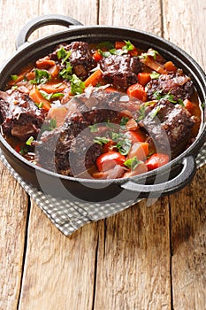 Spanish Bull Tail Stew Rabo De Toro closeup on a pot on the table. Vertical