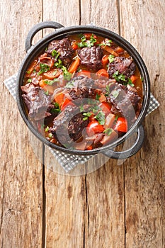 Spanish Bull Tail Stew Rabo De Toro closeup on a pot on the table. Vertical top view