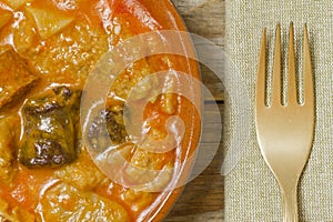 Spanish callos, golden fork and one napkin