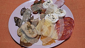 Spanish Chef snackes rotating food plate with york ham, potato chips, egg with black salt, salami chorizo,marmalade