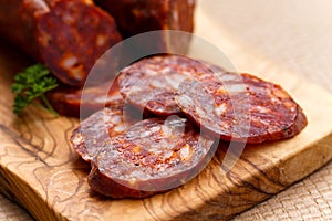 Spanish chorizo sausage with parsley on rustic boa photo