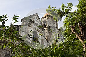 Spanish church dome in gothic style beneath green trees