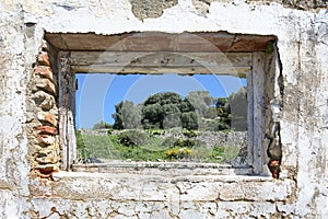 Spanish countryside seen through hole in wall of ruins