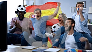 Spanish fans celebrating goal, watching match on tv at home, togetherness
