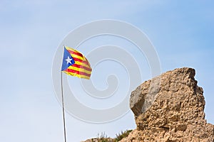 The Spanish flag Estelada on the mountain, over blue sky background, Catalunya, Spain. Copy space for text.