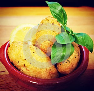 Spanish food Tapas - Bolos de Bacalhau - fish potatoe balls with Basil in a little plate photo