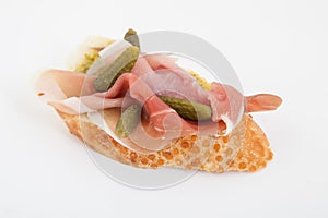 Spanish food tapas.Toast with prosciutto and small gherkins