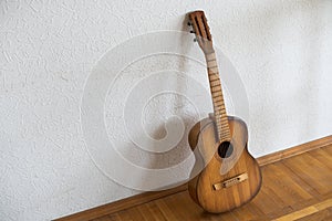 spanish guitar on a old chair with wooden background horizontal