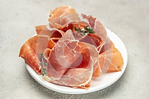 Spanish ham jamon. Slices of prosciutto di parma or jamon serrano on plate. Food recipe background. Close up