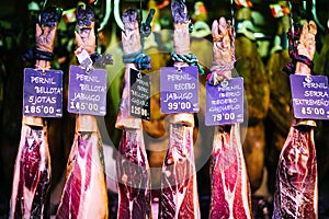 Spanish hamon in barcelona market, jamon iberico in view black leg pork isolated, traditional national spain meat in store