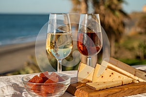 Spanish hard Andalusian cheese filled with sweet sherry served outdoor with membrillo jam with two glasses of sherry wine with