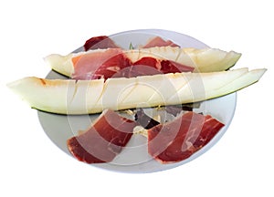 Spanish jamon with melon close up. Melon with serrano hamisolated over white. Typical dish in Spain