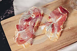 Spanish jamon Serrano, against a stone background.