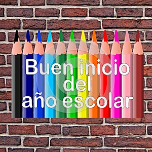 In Spanish language Good return to school written on colored pencils and a brick wall