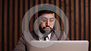 spanish man sitting in office with laptop